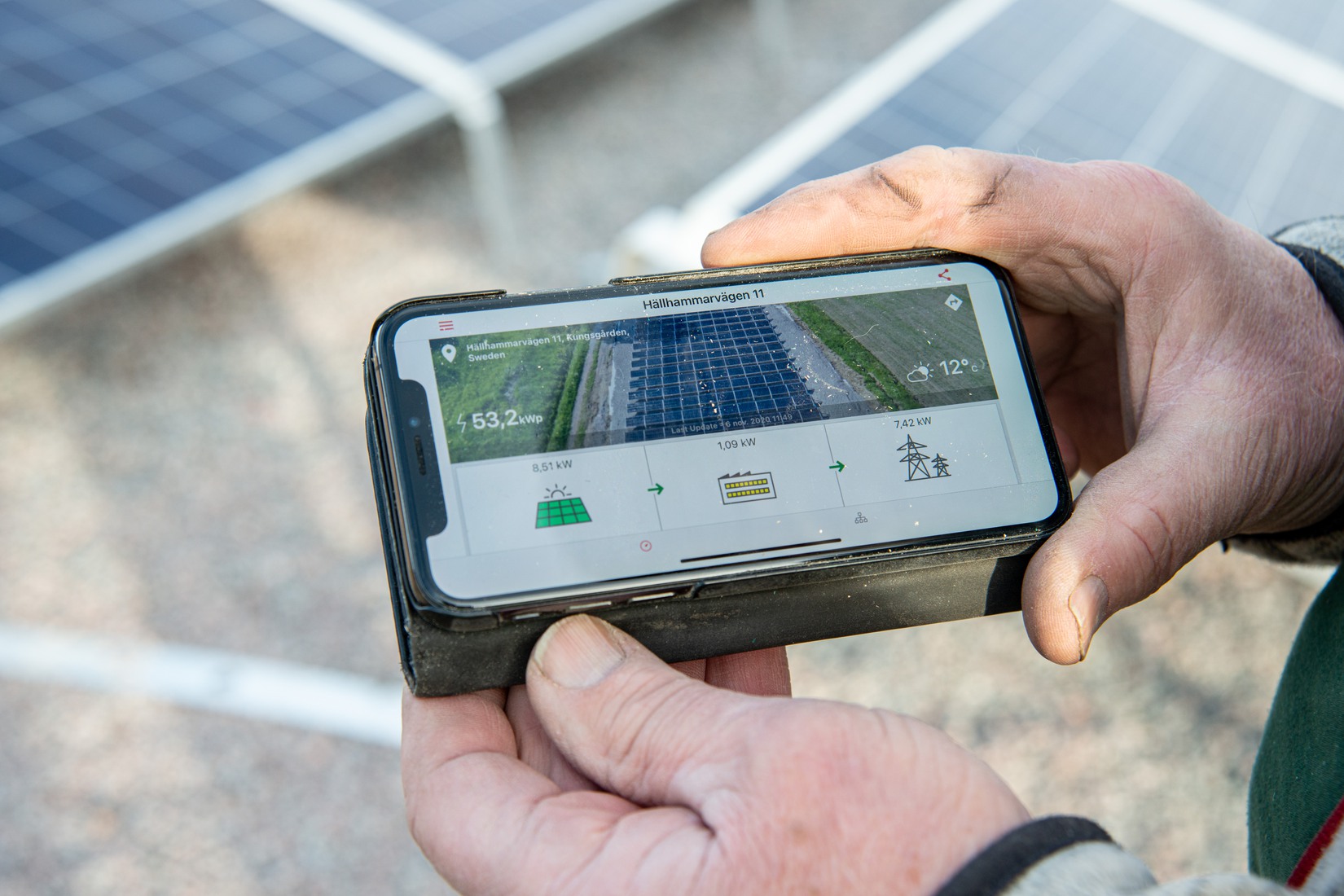 Närbild på telefon med app som visar produktionen från solceller i realtid.