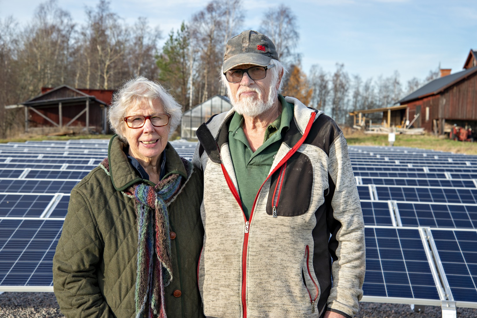 Helge och Marianne Berglund framför solcellerna på gården.