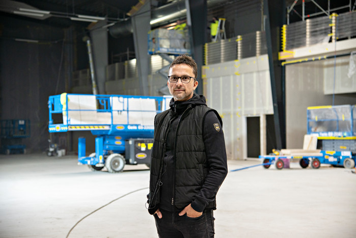 Mathias Woxlin inne i padelhallen med byggmaskiner i bakgrunden.