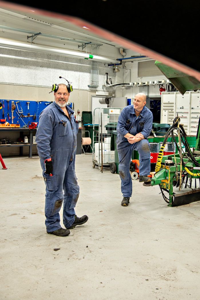 Bild på två reparatörer i verkstaden.