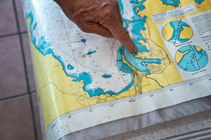 Karta över Storsjön med finger som pekar på en udde.